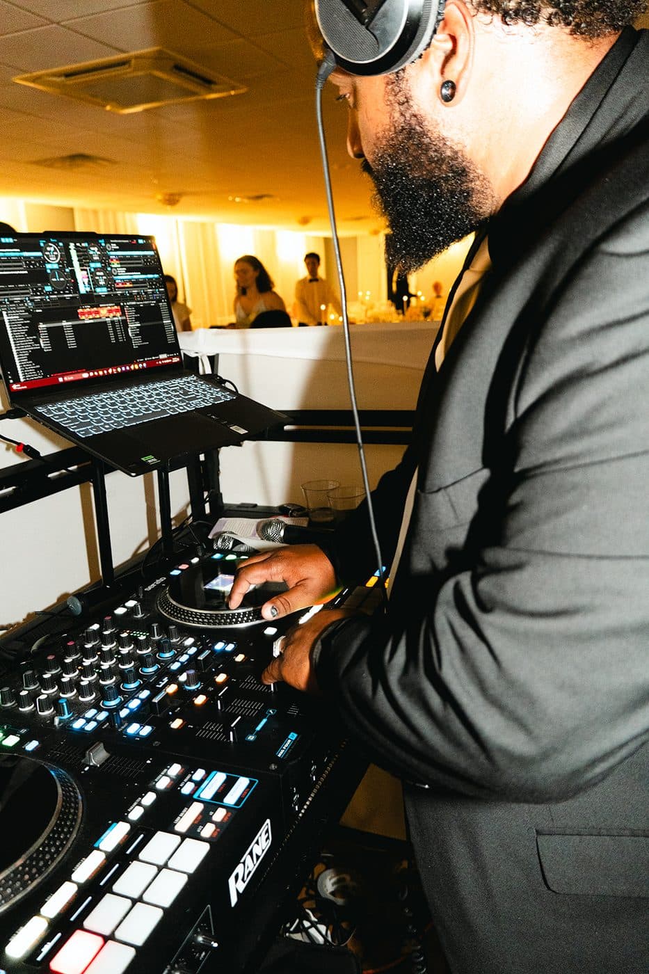 Austin Blackwell, founder of BB Events, mixing in headphones at a wedding reception.